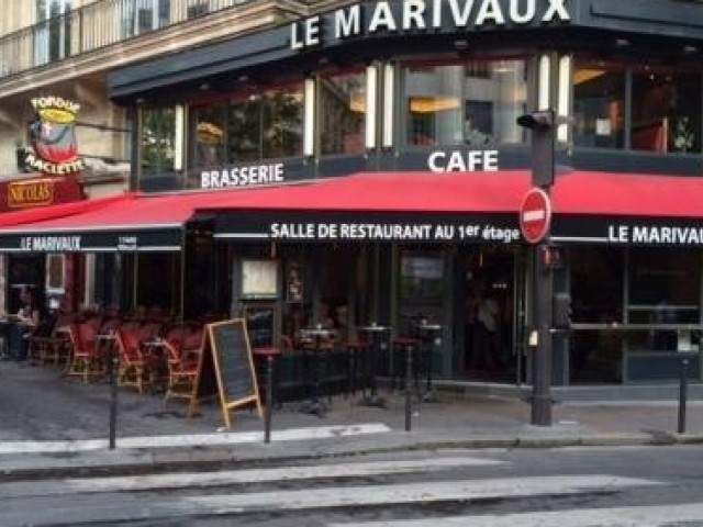 Façade du restaurant Le Marivaux, brasserie parisienne avec auvent rouge et terrasse